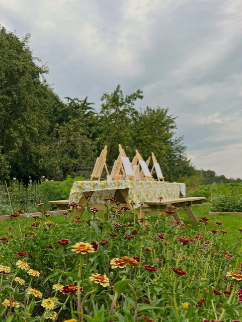 Picknicktafel met schildersezels in een bloementuin