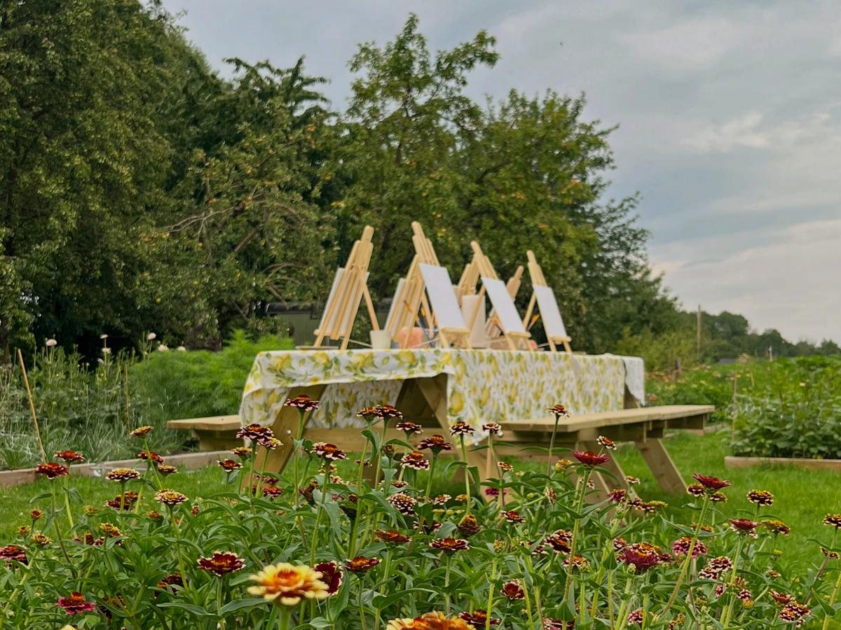 Schildersezels op een tafel tussen de zinnia's